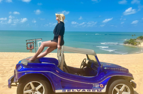 Mulher sentada em cima de um buggy nas Dunas de Genipabu/ RN
